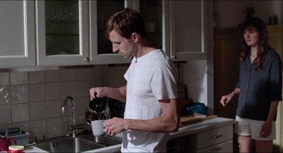 a man and a woman standing in a kitchen