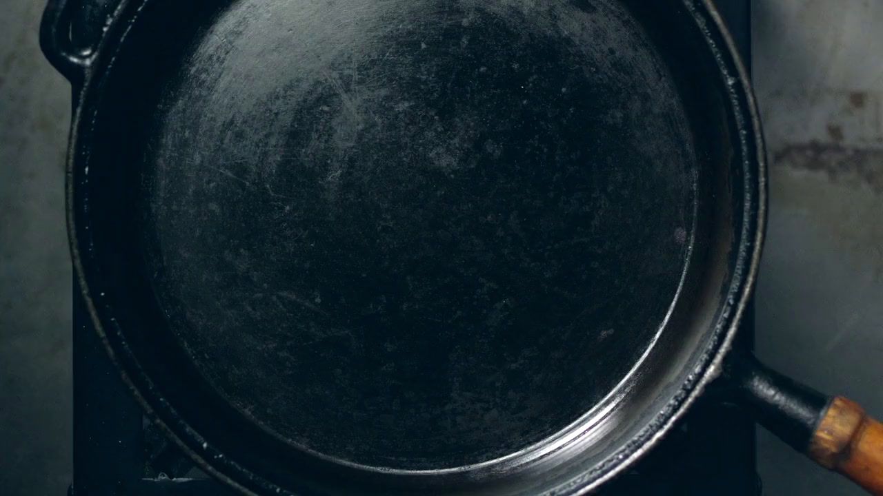 a pan sitting on top of a stove with a wooden handle