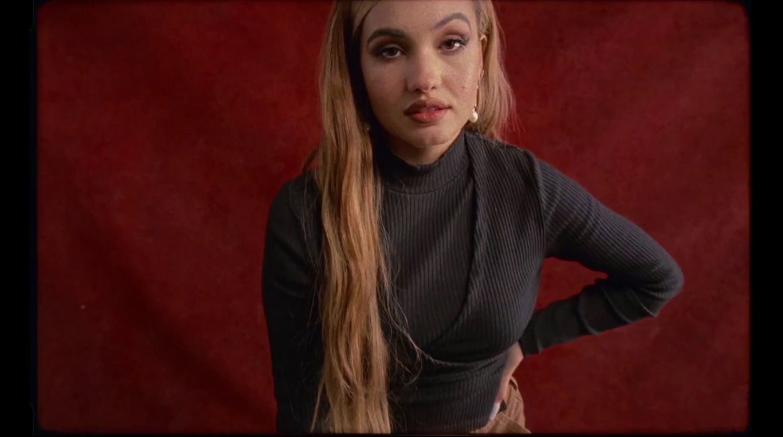 a woman with long hair standing in front of a red background