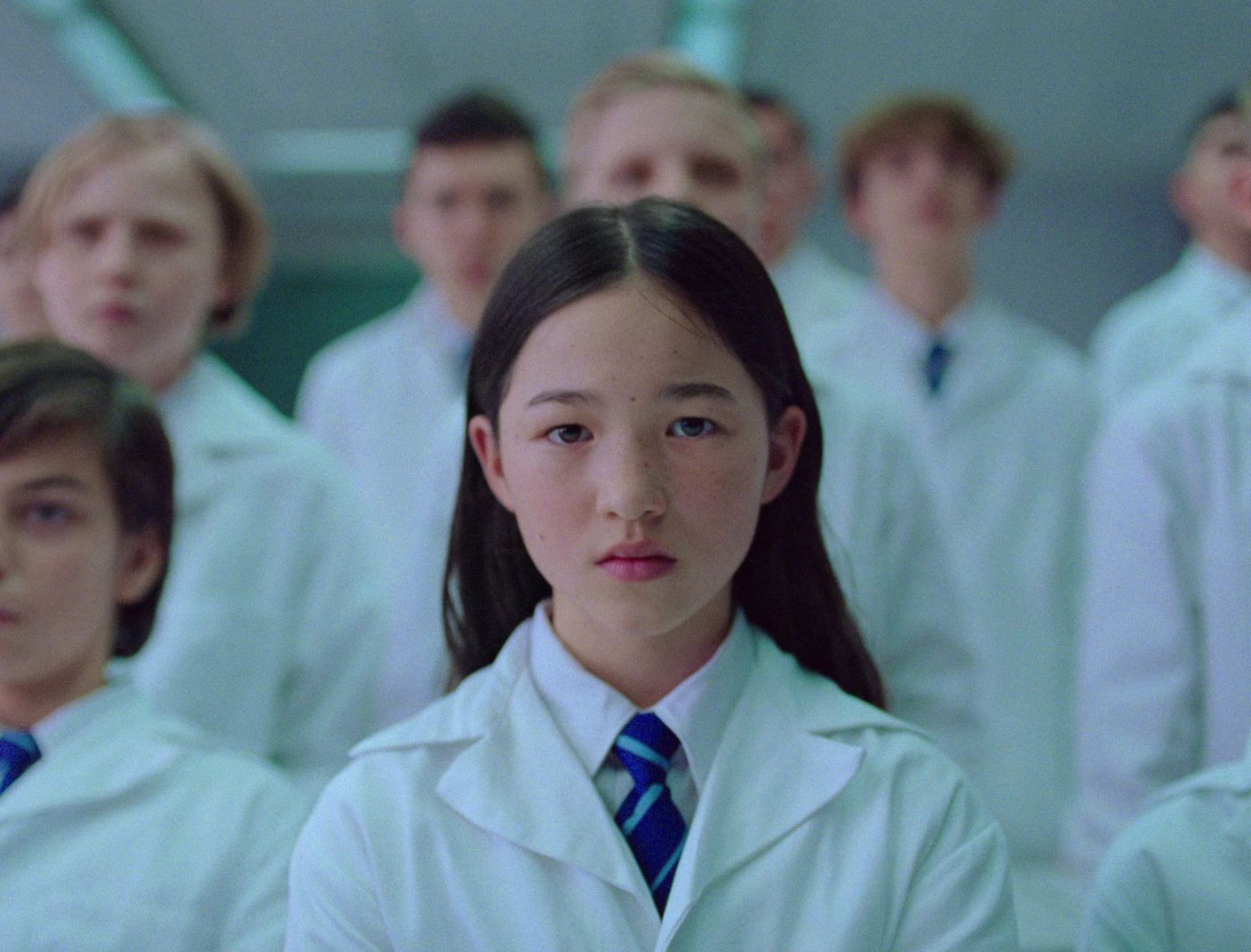 a group of young people wearing lab coats