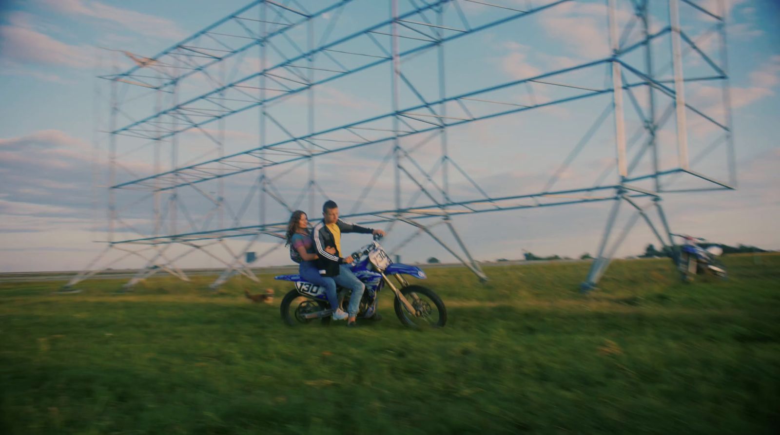 two people on a motorcycle in a field