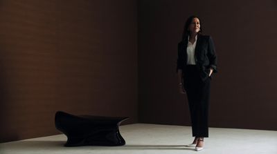 a woman standing in a room next to a chair