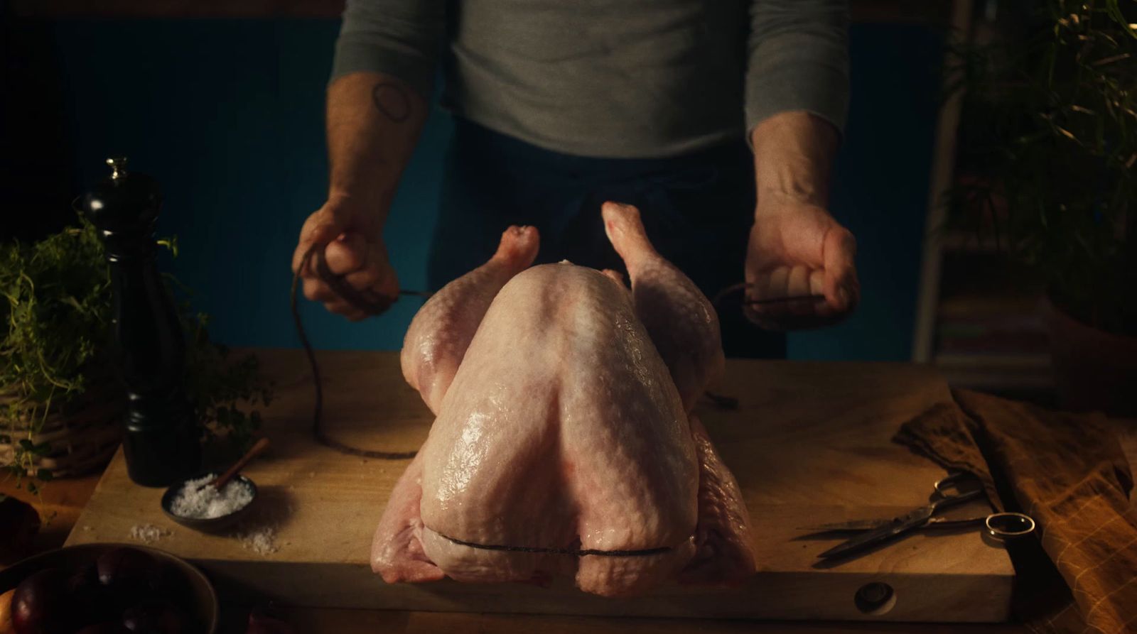 a person holding a knife and a turkey on a cutting board