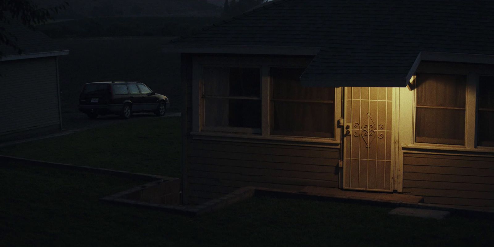 a car parked in front of a house at night