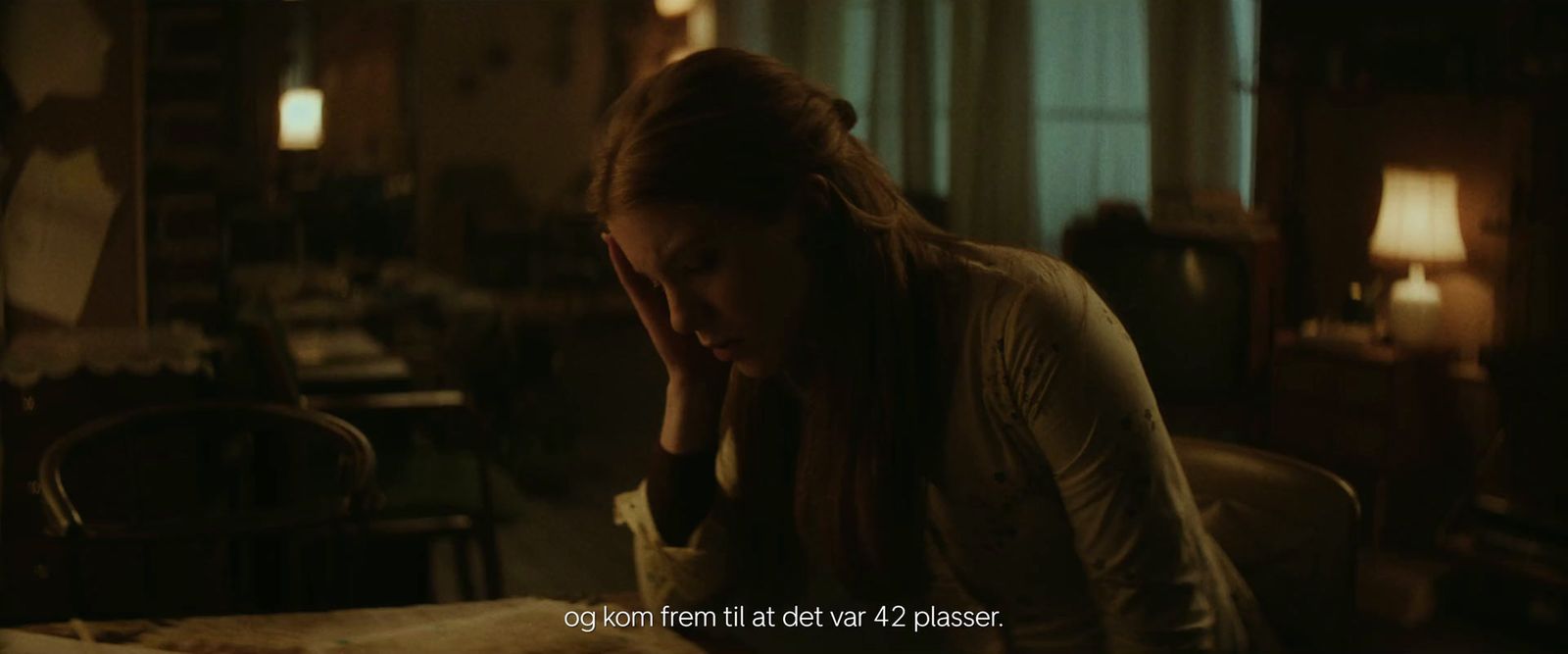 a woman sitting at a table with her head in her hands