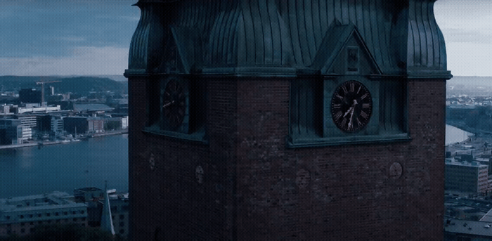 a clock tower on top of a building with a city in the background