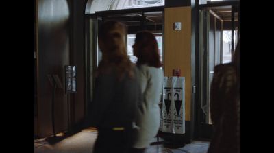 a woman standing in front of a glass door