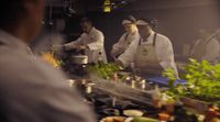 a group of chefs preparing food in a kitchen