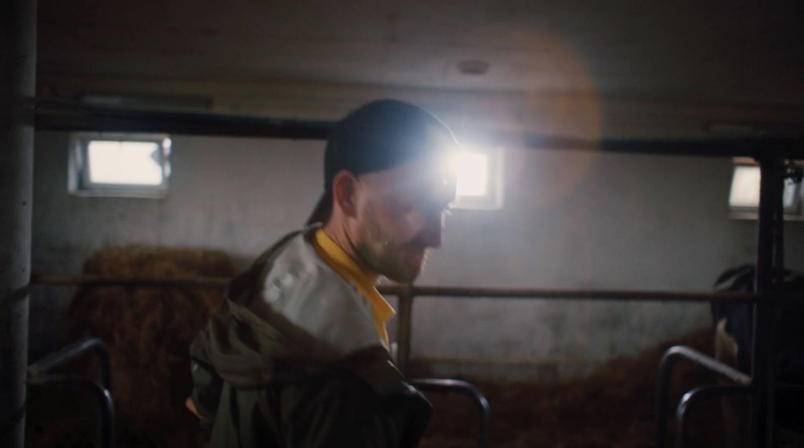 a man standing in a barn with a light on his head