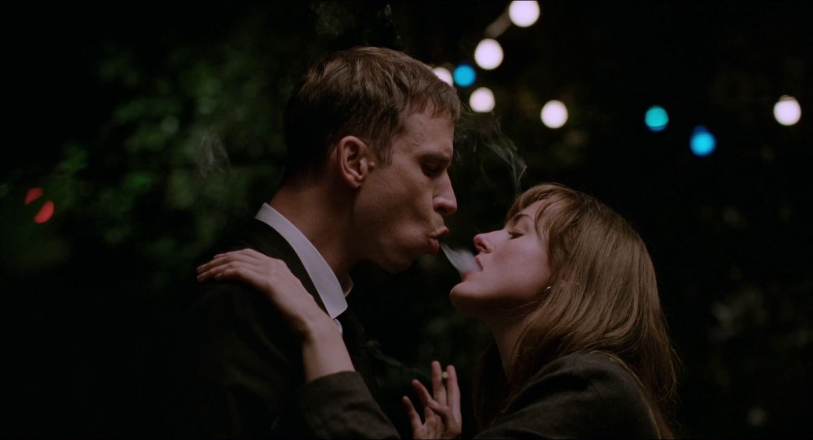 a man and a woman are kissing in the dark