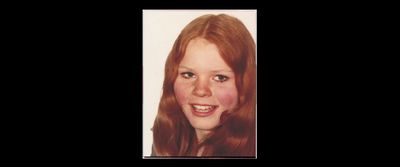 a woman with long red hair smiling for a picture