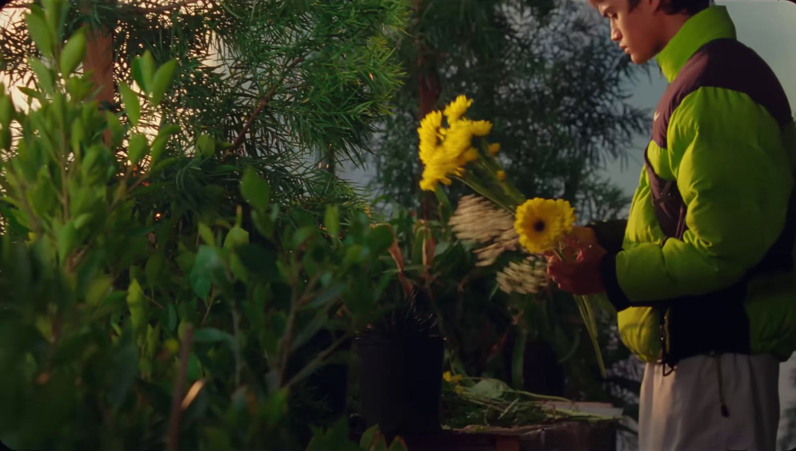 a man holding a bunch of yellow flowers