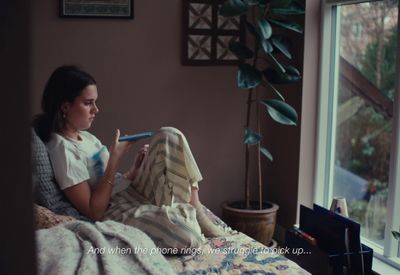 a woman sitting on a bed reading a book