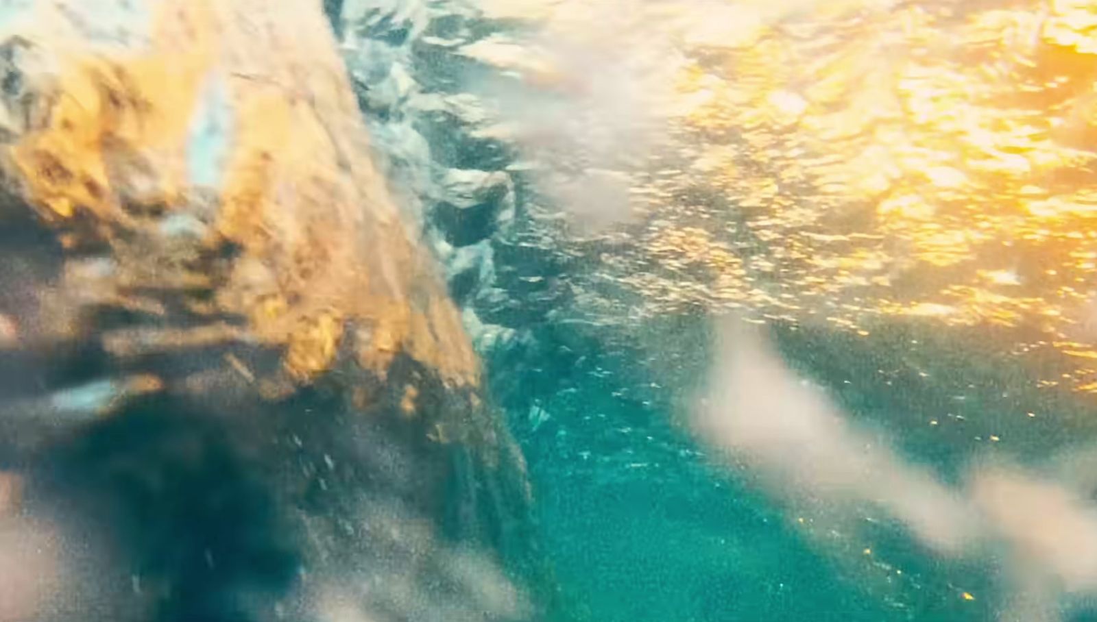 a close up of water with a rock in the background