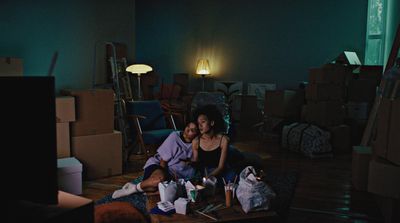 two people sitting on the floor in a dark room