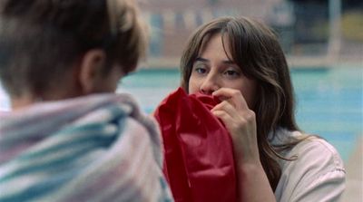 a woman covering her face with a red scarf