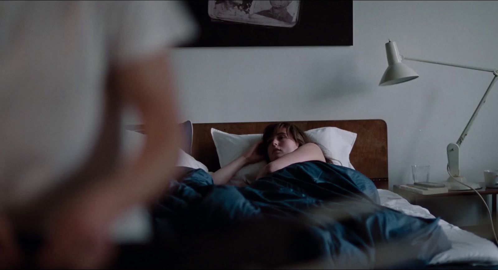 a woman laying in bed with her head on the pillow