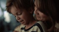 a woman and a child looking at a cell phone