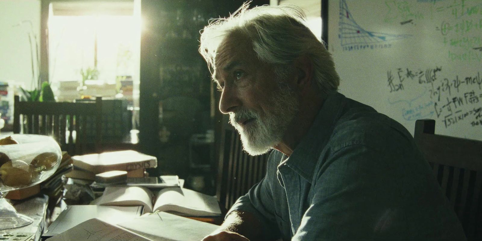 a man sitting at a table with a book in front of him