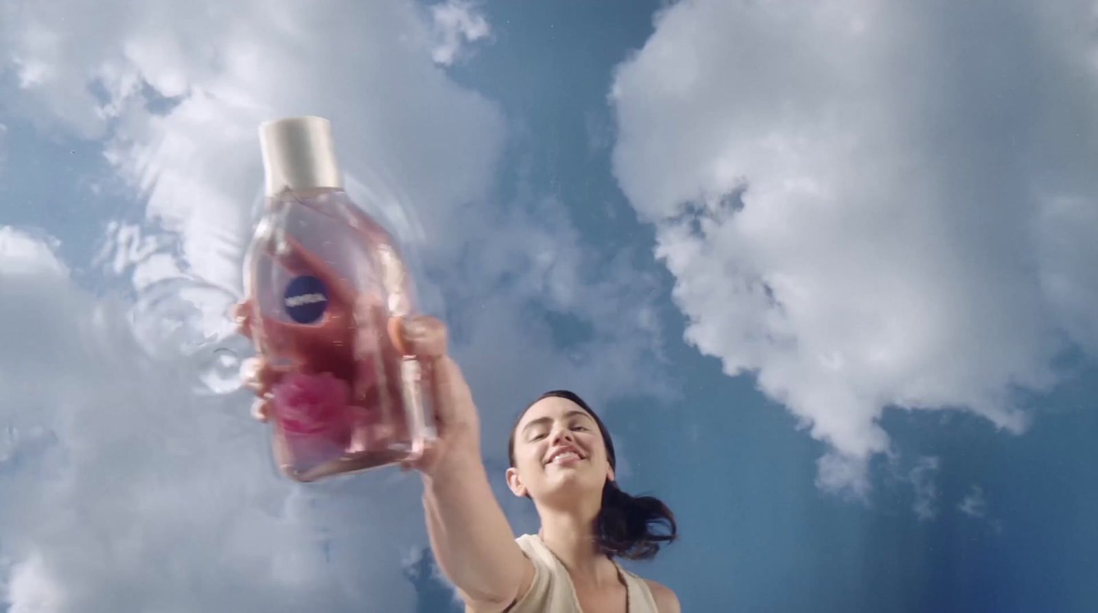 a woman holding a bottle of liquid up in the air