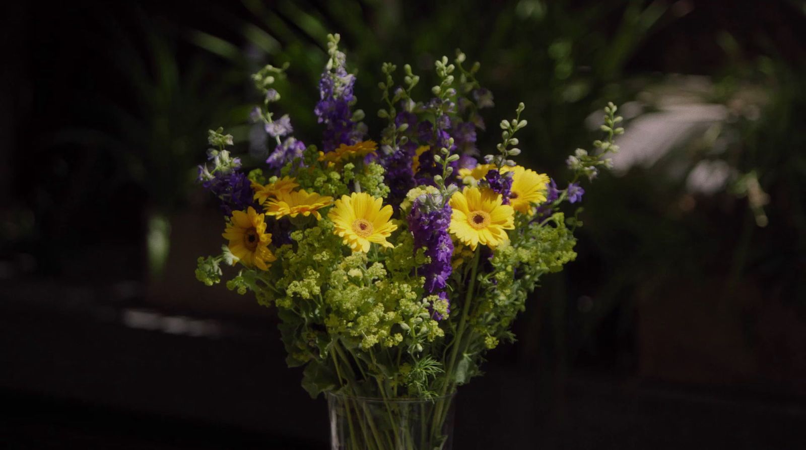 a vase filled with yellow and purple flowers