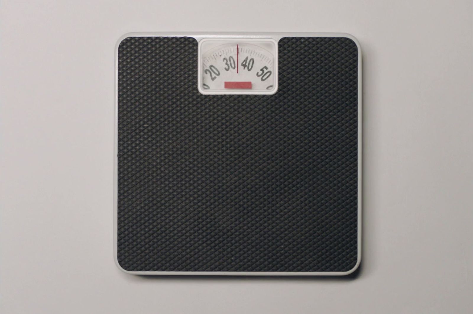 a bathroom scale with a red button on it