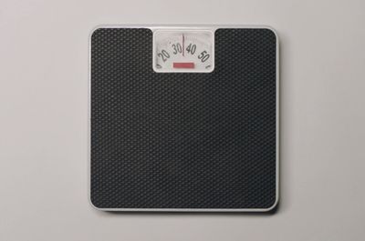 a bathroom scale with a red button on it