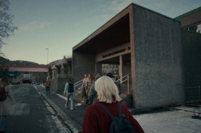 a group of people walking down a street next to a building