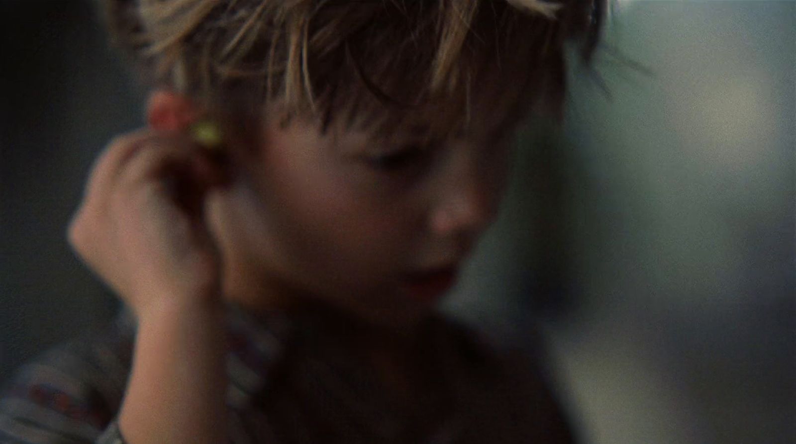 a young boy holding a cell phone to his ear