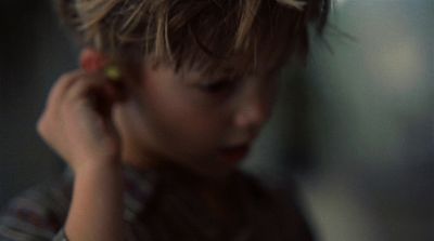 a young boy holding a cell phone to his ear