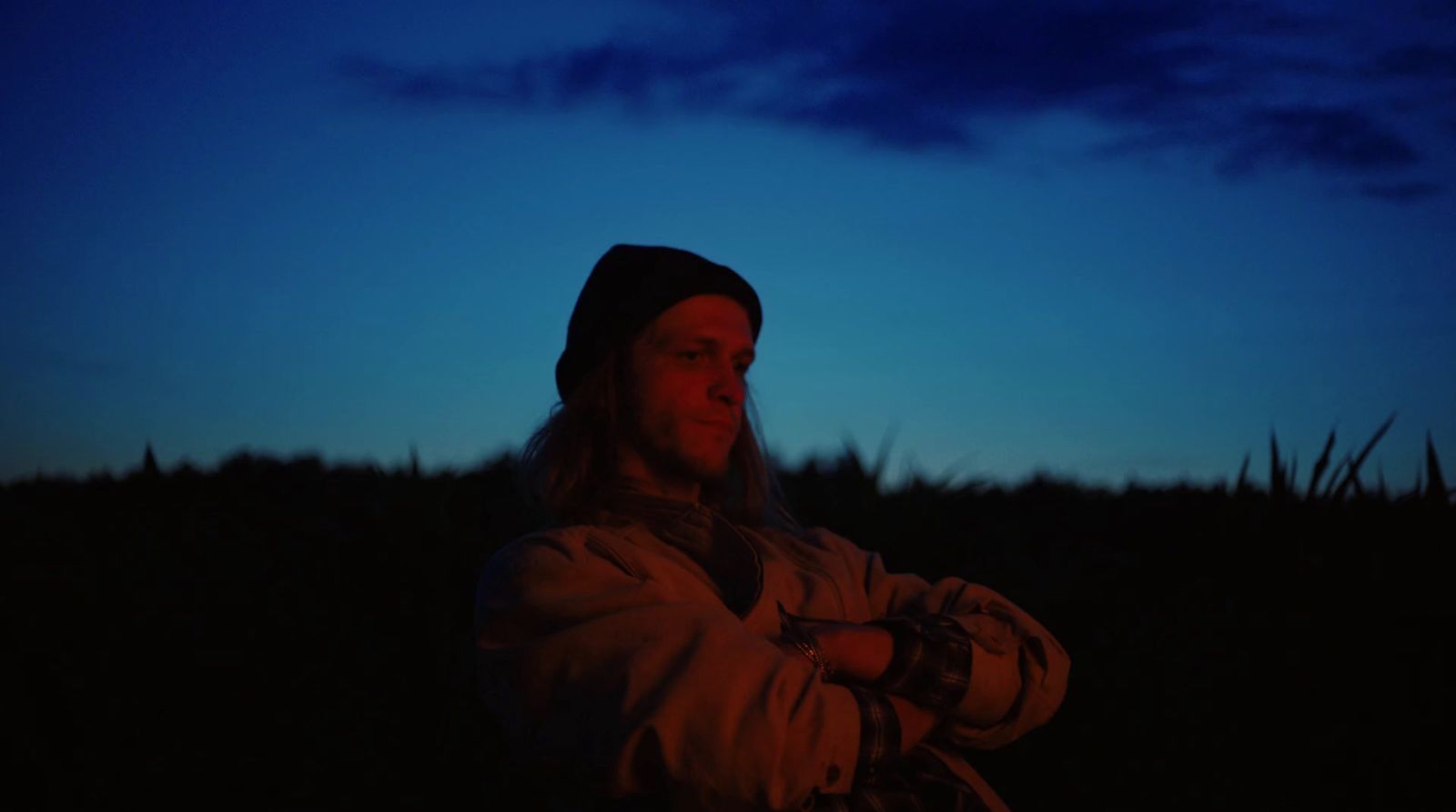 a woman standing in a field at night