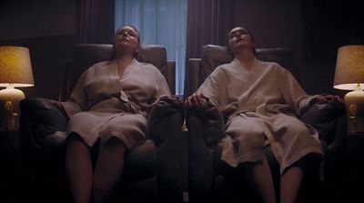 two women in robes sitting in a chair