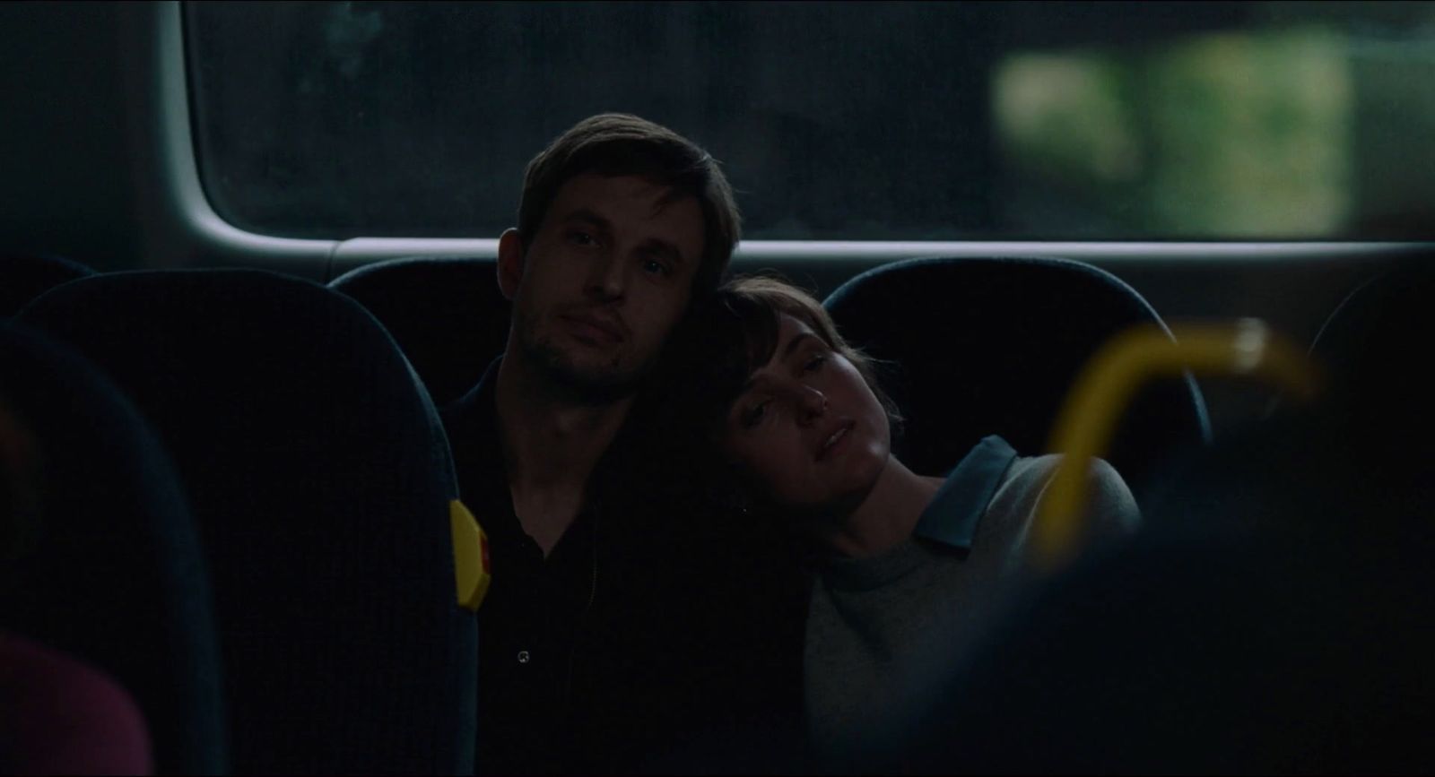 a man and a woman sitting on a bus