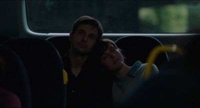 a man and a woman sitting on a bus