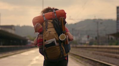 a person with a backpack and a cup of coffee