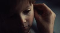 a close up of a child holding his head
