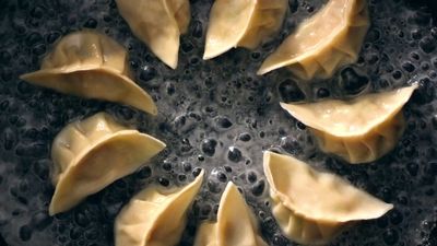 a pan filled with dumplings on top of a stove