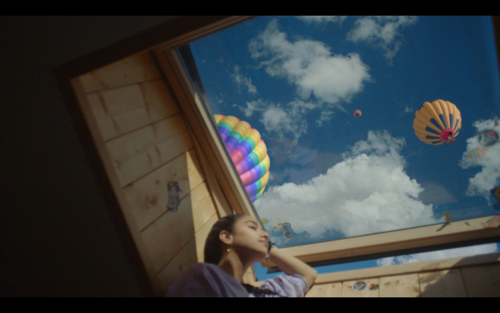 a girl looking up at the sky through a window