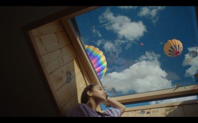 a girl looking up at the sky through a window