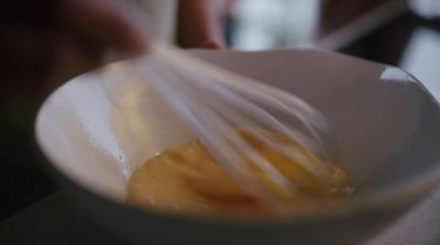 a white bowl with a yellow liquid inside of it