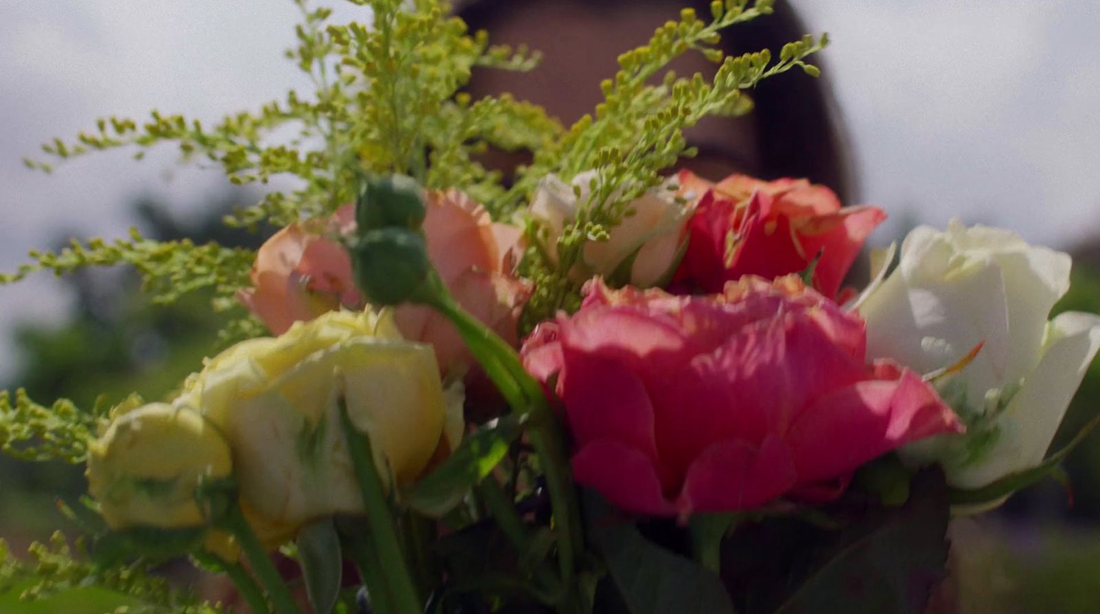 a vase filled with lots of different colored flowers