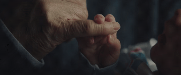 an older person holding their hand up to their face
