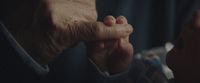 an older person holding their hand up to their face