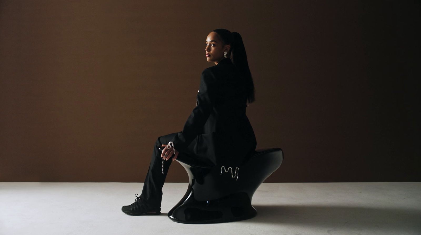 a woman sitting on top of a black chair