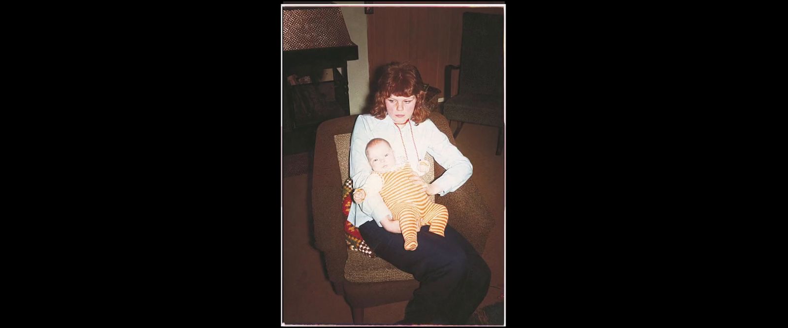 a woman sitting on a couch holding a baby