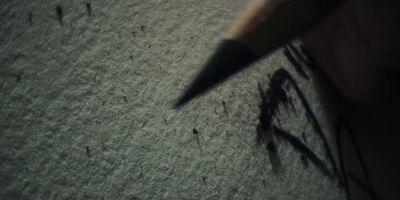 a close up of a person's hand holding a pen