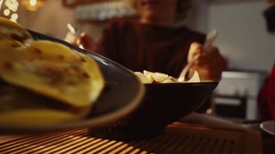 a person sitting at a table with a plate of food