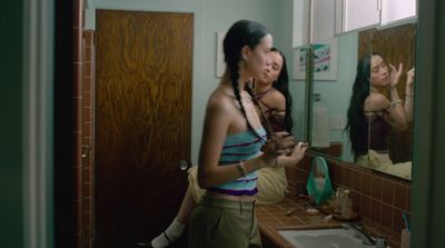 a woman standing in front of a bathroom mirror