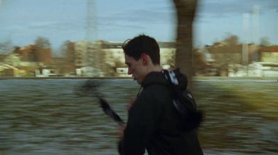 a man walking down a street holding a cell phone