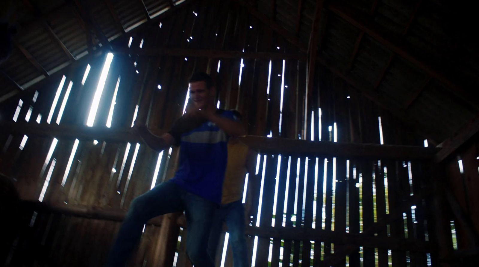 a man in a blue shirt standing in a room